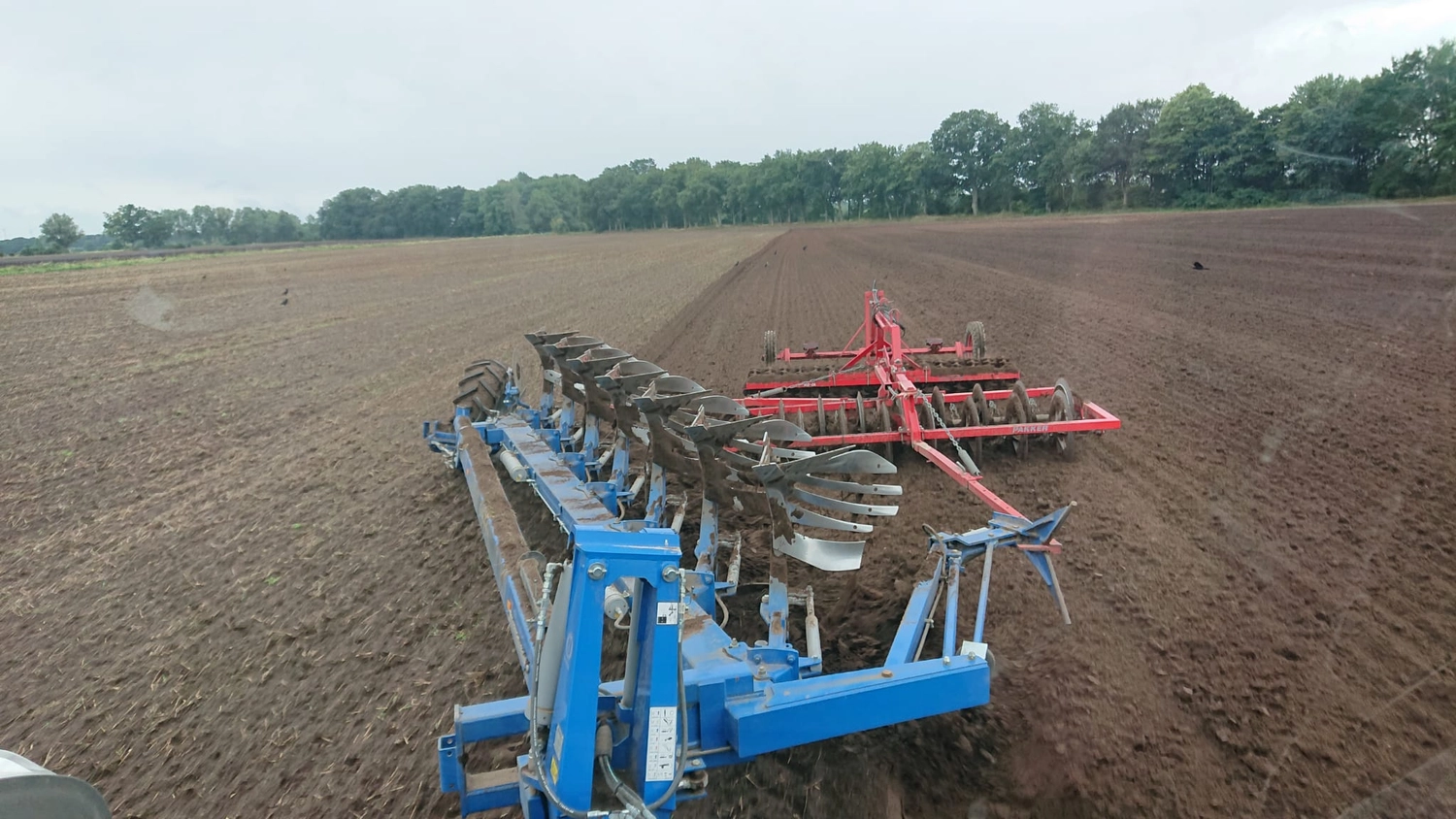 Agrargemeinschaft Holthusen e.G. - Landwirtschaftlicher - Schwere landwirtschaftliche Maschinen bearbeiten ein großes Feld
